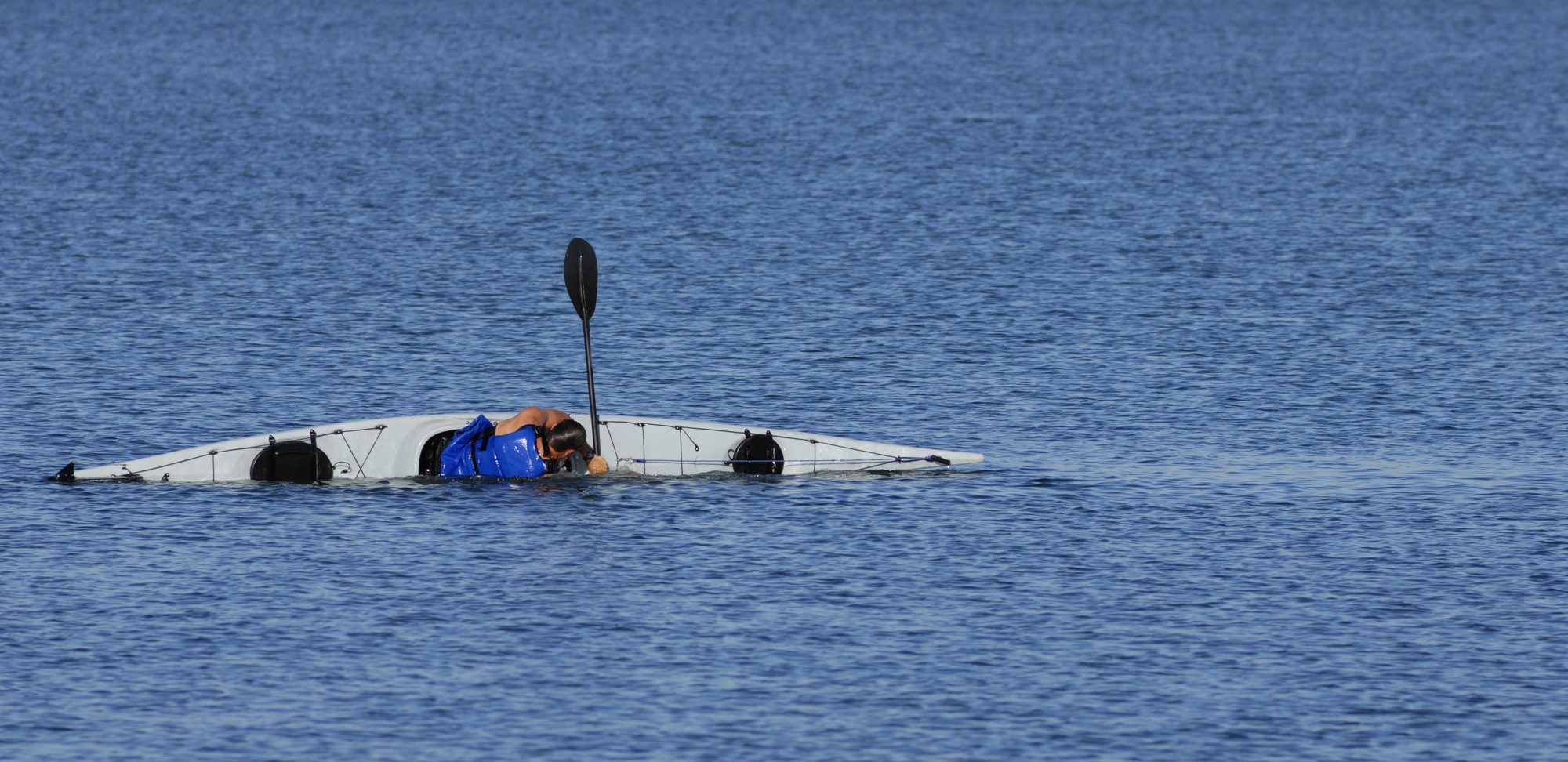 kayaker in open water performing eskimo roll